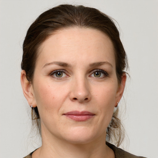 Joyful white young-adult female with medium  brown hair and grey eyes