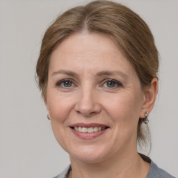 Joyful white adult female with medium  brown hair and grey eyes