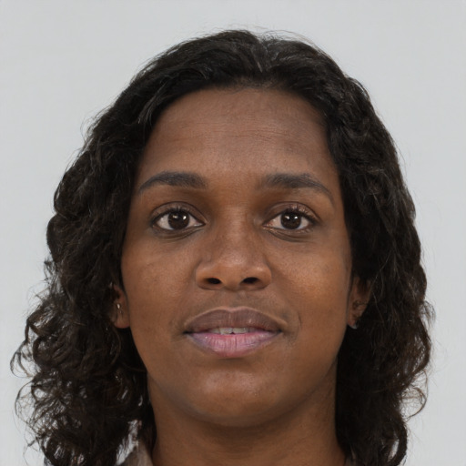 Joyful black young-adult female with long  brown hair and brown eyes