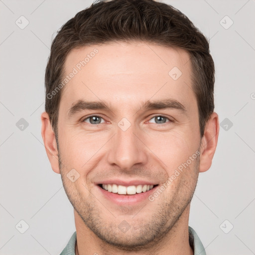 Joyful white young-adult male with short  brown hair and grey eyes