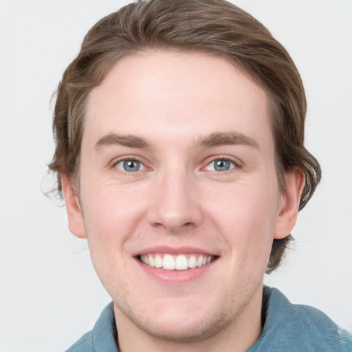 Joyful white young-adult male with short  brown hair and blue eyes