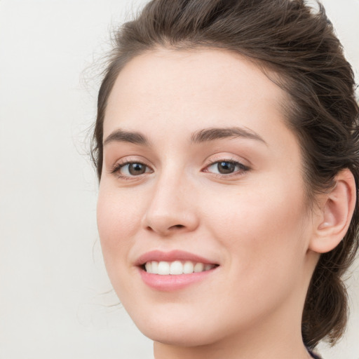 Joyful white young-adult female with long  brown hair and green eyes