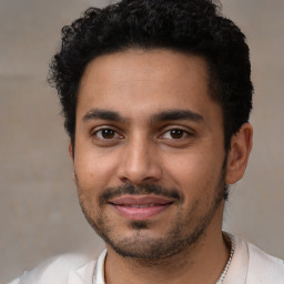 Joyful latino young-adult male with short  black hair and brown eyes