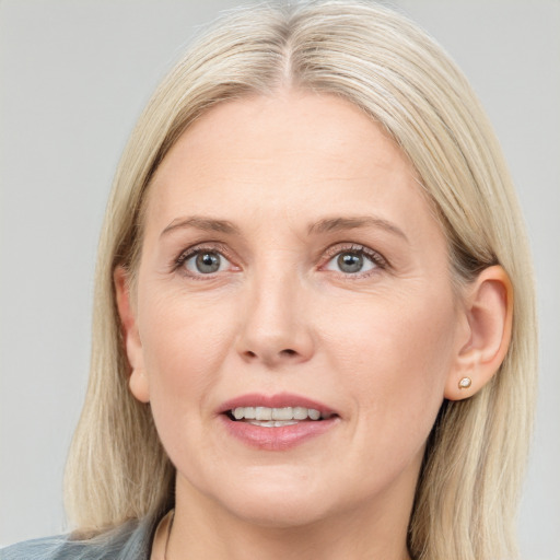 Joyful white adult female with medium  brown hair and blue eyes