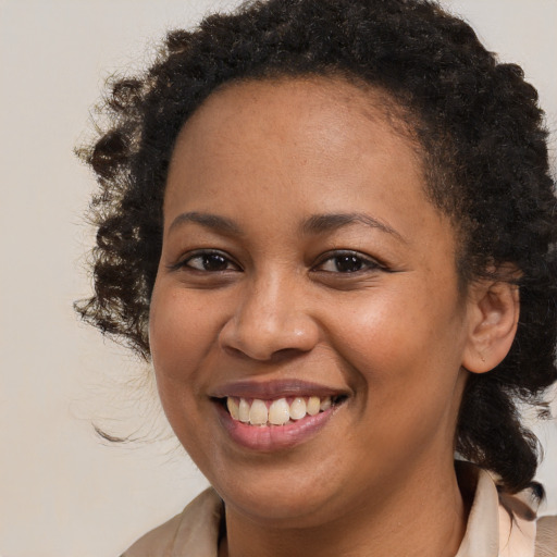 Joyful black young-adult female with medium  brown hair and brown eyes