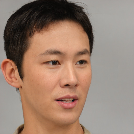 Joyful asian young-adult male with short  brown hair and brown eyes