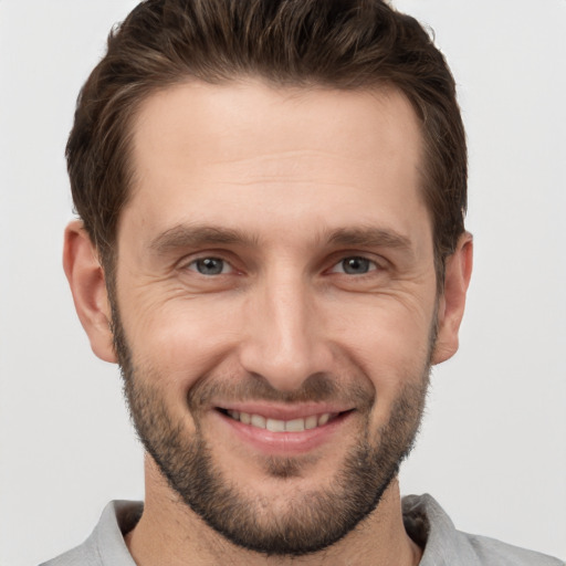 Joyful white young-adult male with short  brown hair and grey eyes