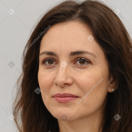 Joyful white adult female with long  brown hair and brown eyes