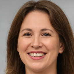 Joyful white adult female with long  brown hair and brown eyes