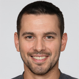 Joyful white young-adult male with short  brown hair and brown eyes