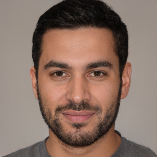 Joyful white young-adult male with short  black hair and brown eyes