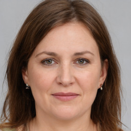 Joyful white adult female with long  brown hair and grey eyes