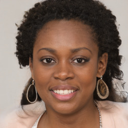 Joyful black young-adult female with long  brown hair and brown eyes