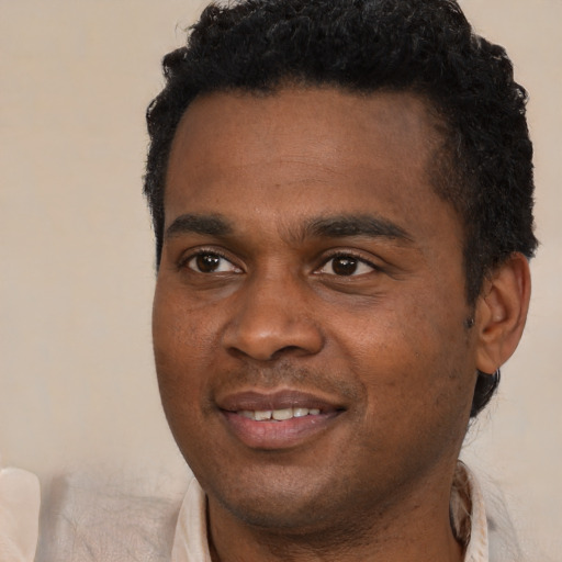 Joyful black young-adult male with short  black hair and brown eyes