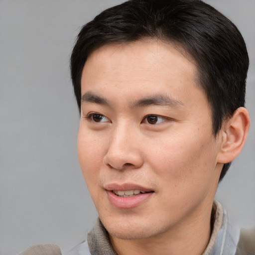 Joyful asian young-adult male with short  brown hair and brown eyes