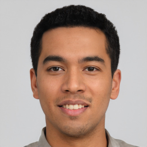 Joyful latino young-adult male with short  black hair and brown eyes