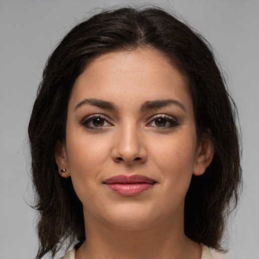 Joyful latino young-adult female with medium  brown hair and brown eyes