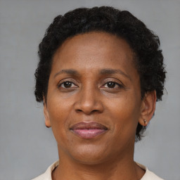 Joyful black adult female with short  brown hair and brown eyes