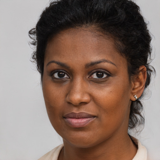Joyful black young-adult female with long  brown hair and brown eyes