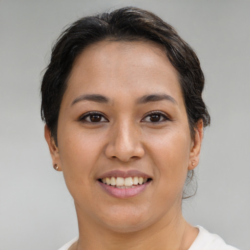 Joyful latino young-adult female with medium  brown hair and brown eyes