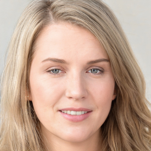 Joyful white young-adult female with long  brown hair and blue eyes