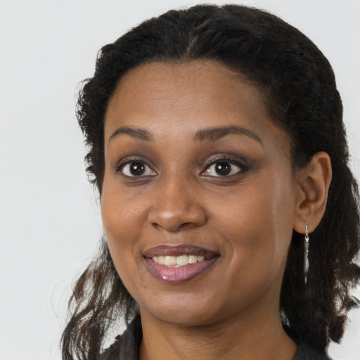 Joyful black young-adult female with long  brown hair and brown eyes