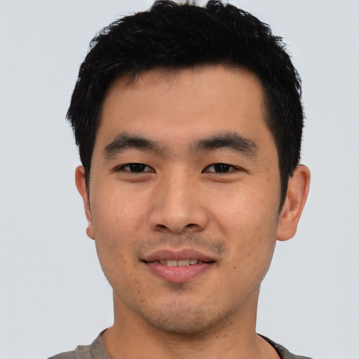 Joyful asian young-adult male with short  black hair and brown eyes