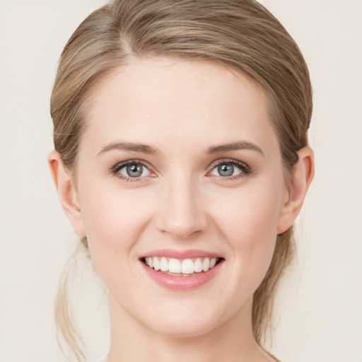 Joyful white young-adult female with medium  brown hair and green eyes