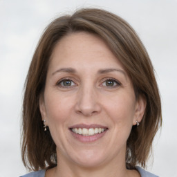 Joyful white adult female with medium  brown hair and grey eyes