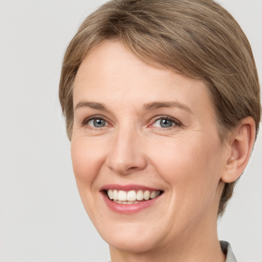 Joyful white adult female with medium  brown hair and grey eyes