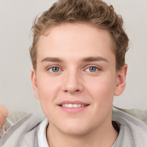 Joyful white young-adult male with short  brown hair and blue eyes