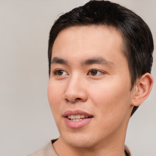 Joyful asian young-adult male with short  brown hair and brown eyes