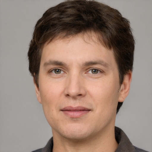 Joyful white adult male with short  brown hair and grey eyes