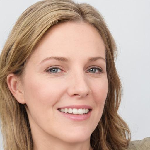 Joyful white young-adult female with long  brown hair and blue eyes