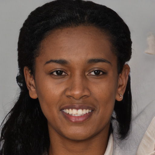 Joyful black young-adult female with long  black hair and brown eyes