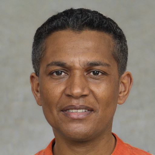 Joyful black young-adult male with short  black hair and brown eyes