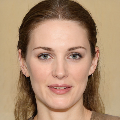 Joyful white young-adult female with medium  brown hair and green eyes