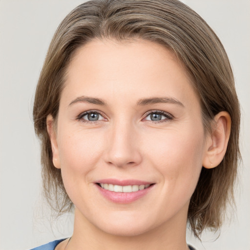 Joyful white young-adult female with medium  brown hair and grey eyes