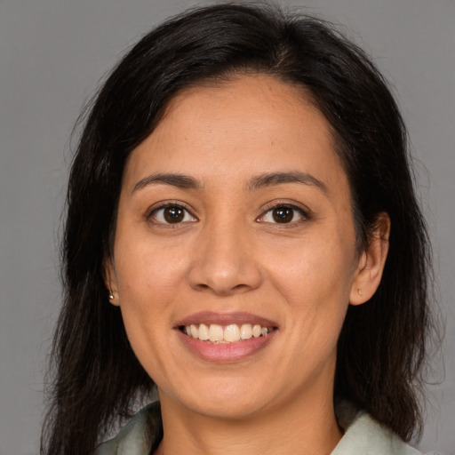 Joyful latino young-adult female with medium  brown hair and brown eyes