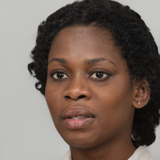 Joyful black young-adult female with medium  black hair and brown eyes