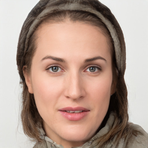 Joyful white young-adult female with medium  brown hair and grey eyes