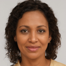 Joyful black adult female with medium  brown hair and brown eyes