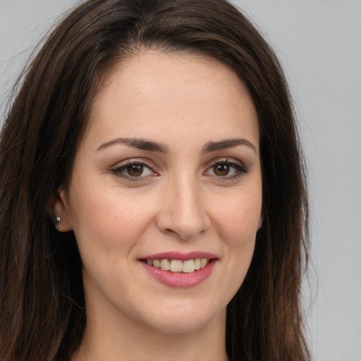 Joyful white young-adult female with long  brown hair and brown eyes