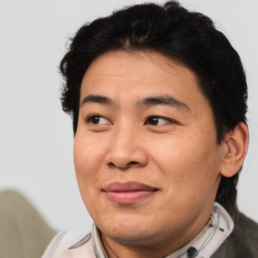 Joyful asian adult male with short  brown hair and brown eyes