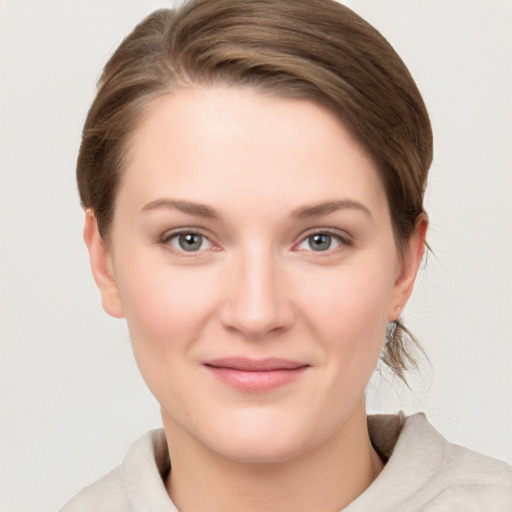 Joyful white young-adult female with medium  brown hair and grey eyes