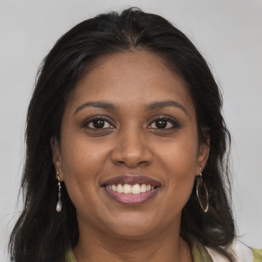 Joyful black young-adult female with long  brown hair and brown eyes