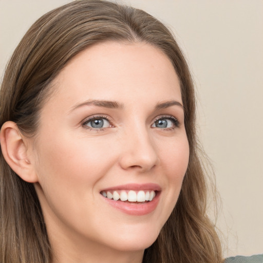 Joyful white young-adult female with long  brown hair and blue eyes