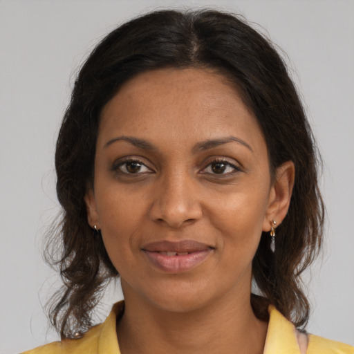 Joyful black adult female with medium  brown hair and brown eyes