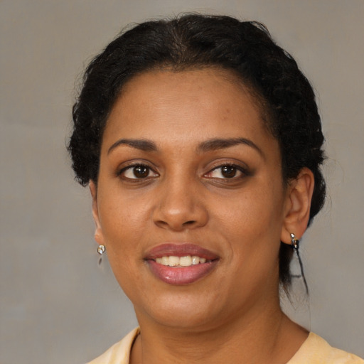 Joyful black adult female with short  brown hair and brown eyes