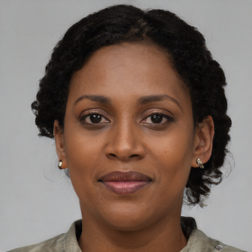 Joyful black adult female with short  black hair and brown eyes